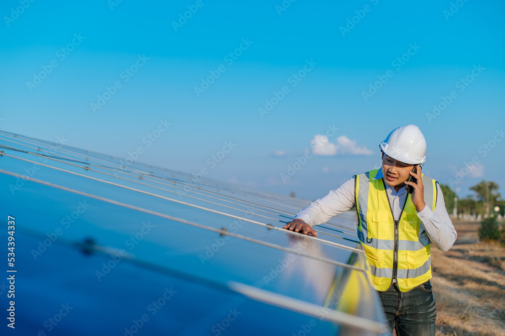 Young engineer use smartphone while working at solar farm Young engineer use smartphone while working at solar farm