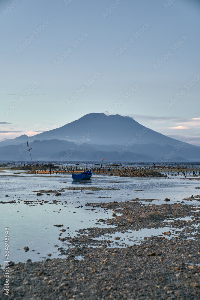 low tide on a small island with a view of mount agung volcano