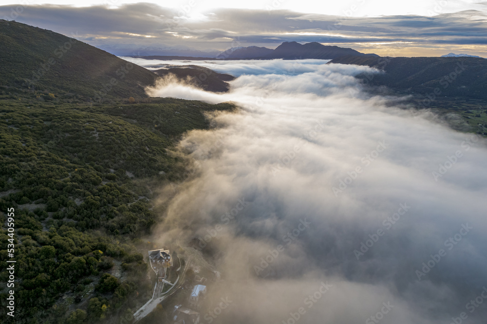 Obraz premium aerial view of Ano Pedina village a misty autumn morning with its architectural traditional old stone buildings located on Tymfi mount, Zagori, Epirus, Greece,