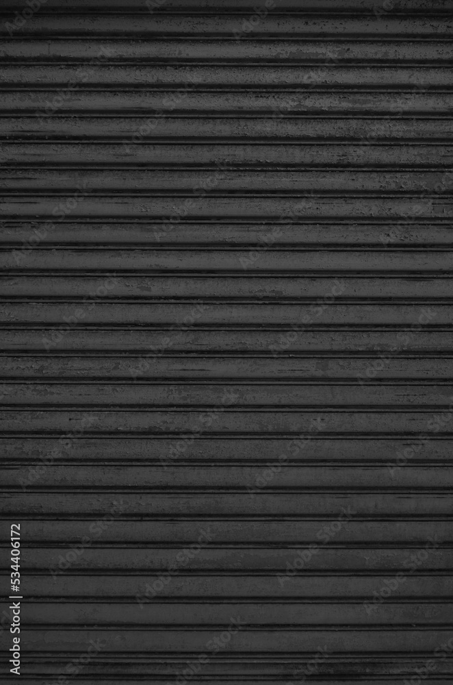 Old desolate corrugated metal roller shutter texture. Grunge metal shutter on store or shop front. Old desolate corrugated metal roller shutter texture. Grunge metal shutter on store or shop front.
