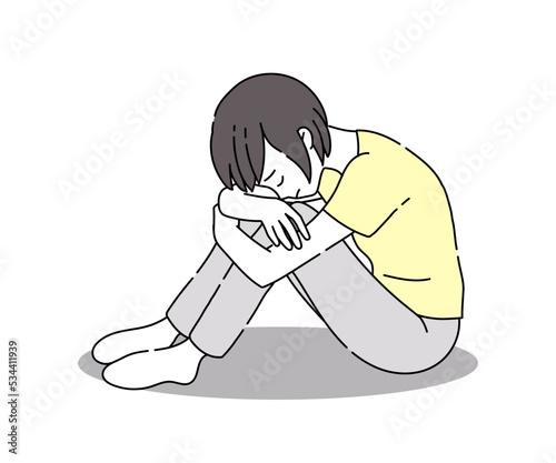 膝を抱え落ち込む女性