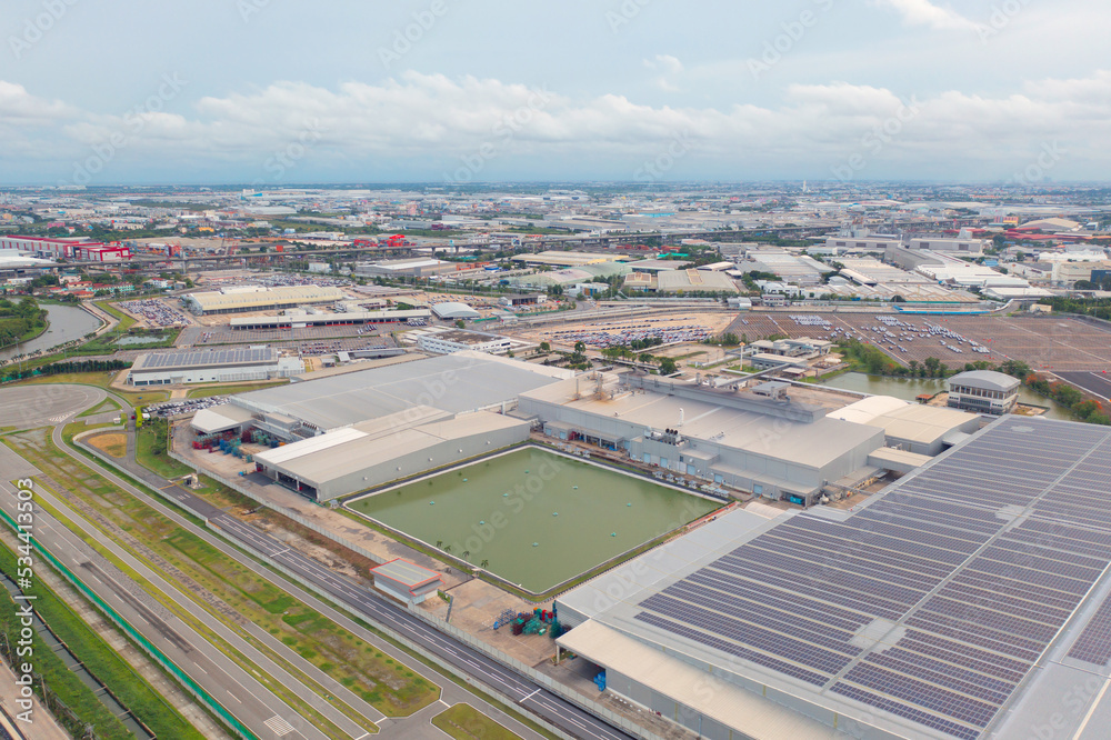 Aerial top view of industry factory in urban city town. Inventory import and export business commercial, Automobile and automotive industry distribution logistic transport with lake and river.