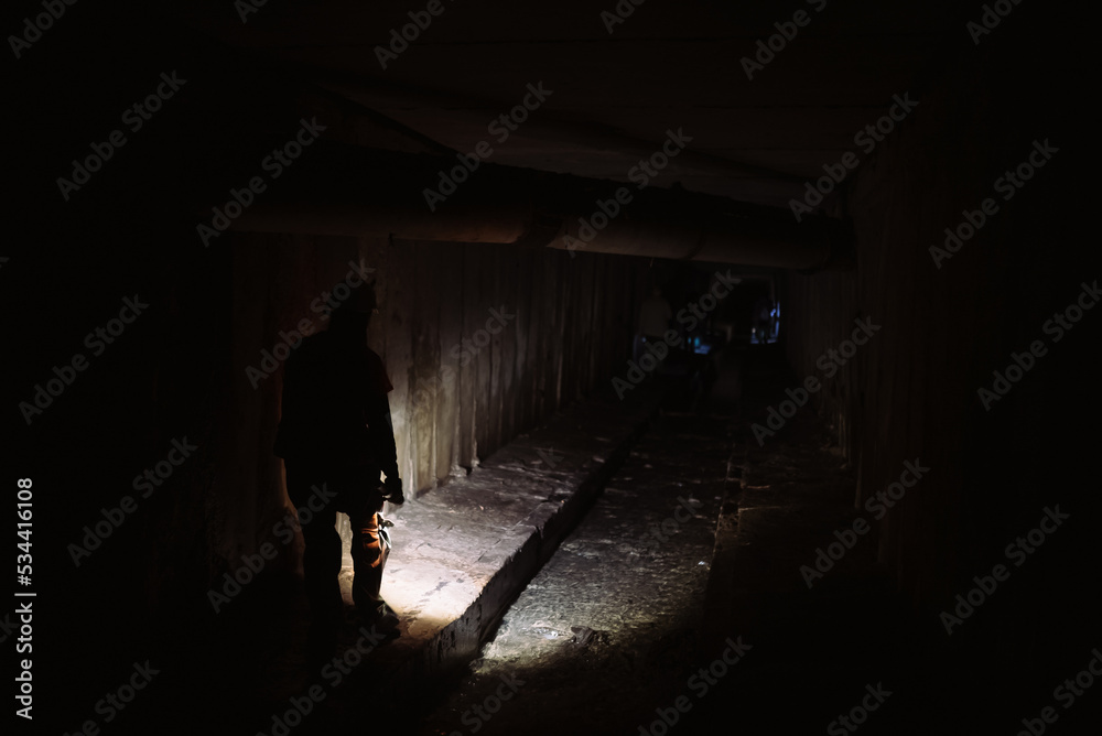 Female digger with flashlight explores the tunnel Female digger with flashlight explores the tunnel