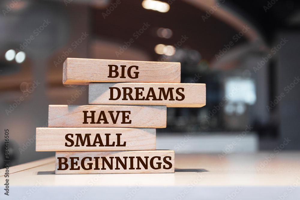 Wooden blocks with words 'Big Dreams Have Small Beginnings'.