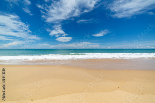 scenery smooth waves from green sea hit on the white long beach..beautiful nature on the beach..white cloud in blue sky background..