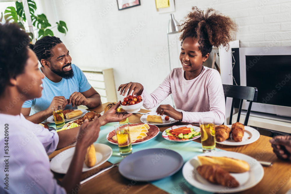 A multi-generational African-American family enjoying food at their dinner table. A multi-generational African-American family enjoying food at their dinner table.