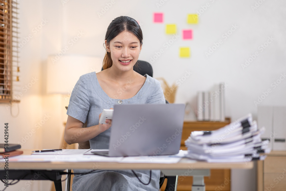 Young business Asian woman working at desk with laptop computer in home office, Tax Accountant Young Asian woman Doing Sales Invoice Accounting. Young business Asian woman working at desk with laptop computer in home office, Tax Accountant Young Asian woman Doing Sales Invoice Accounting.