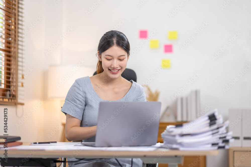 Young business Asian woman working at desk with laptop computer in home office, Tax Accountant Young Asian woman Doing Sales Invoice Accounting. Young business Asian woman working at desk with laptop computer in home office, Tax Accountant Young Asian woman Doing Sales Invoice Accounting.