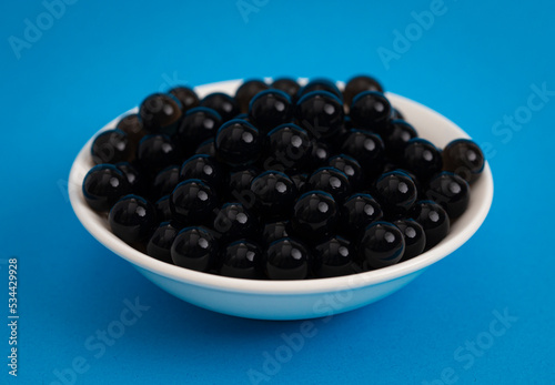 Bowl of Popping Boba Pearls on a Bright Blue Background