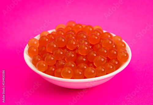 Bowl of Popping Boba Pearls on a Bright Pink Background