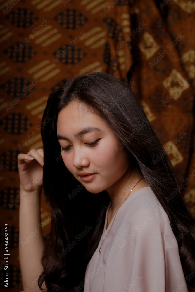 Beauty portrait of happy Asian woman face with natural skin on Indonesian Batik background. Beauty portrait of happy Asian woman face with natural skin on Indonesian Batik background.