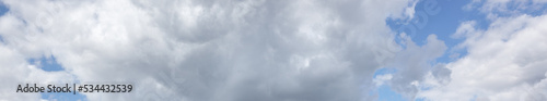 Panoramic photo of blurred sky. Blue sky background with cumulus clouds