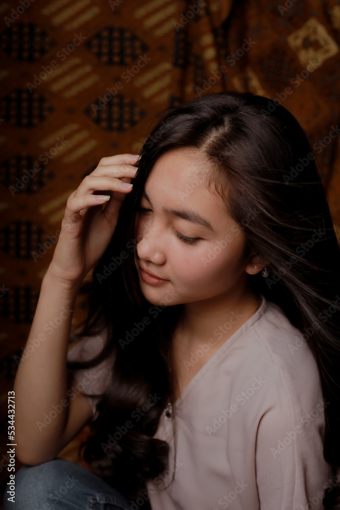 Obraz premium Beauty portrait of happy Asian woman face with natural skin on Indonesian Batik background.