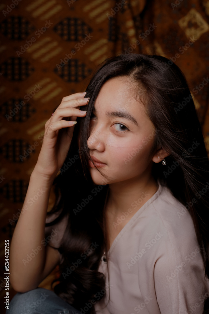 Obraz premium Beauty portrait of happy Asian woman face with natural skin on Indonesian Batik background.