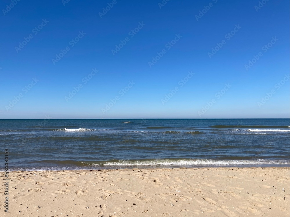 the calm sea with blue sky and sandy beach