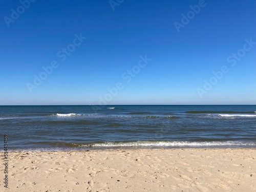 the calm sea with blue sky and sandy beach