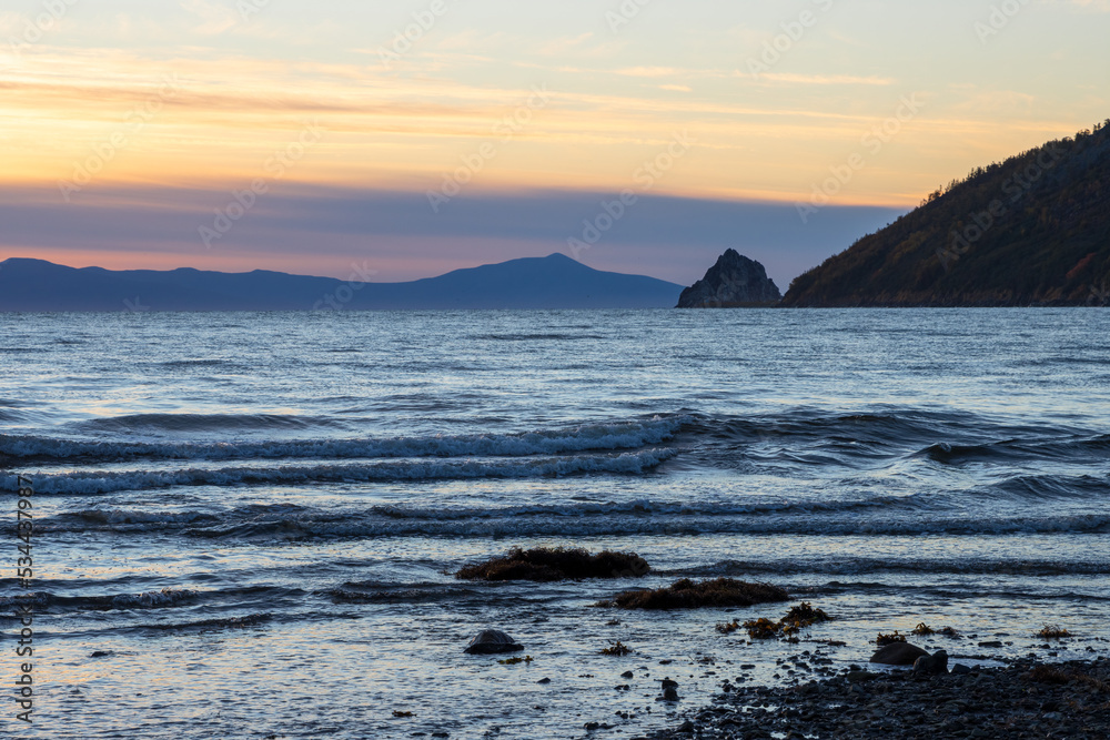 Beautiful morning seascape. View from the shore to the sea, mountains and cape. Sea of Okhotsk, Magadan region, Russian Far East.