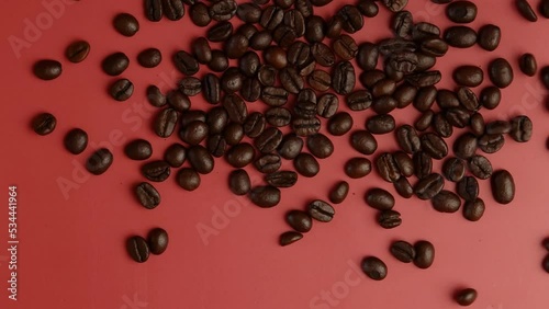 Hands with Roasted Coffee beans over pink top view