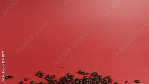 Roasted Coffee beans falling down on pink close up