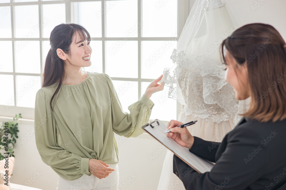 ウェディングプランナーとドレス選び・ベールの打ち合わせをする女性
ウェディングプランナーとドレス選び・ベールの打ち合わせをする女性