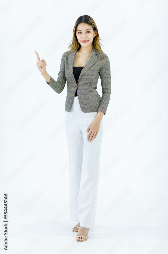 Isolated cutout studio full body shot Millennial Asian successful professional female businesswoman in formal suit standing smiling holding hand pointing finger blank empty space on white background Isolated cutout studio full body shot Millennial Asian successful professional female businesswoman in formal suit standing smiling holding hand pointing finger blank empty space on white background