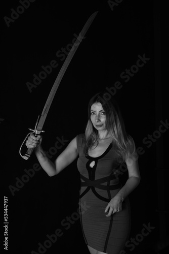 Low key portrait of a woman with vintage sword