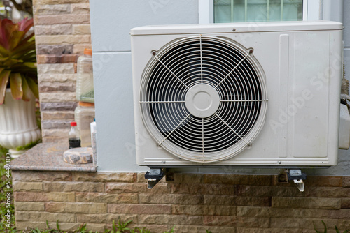 Home air conditioner compressor wall mounted outside the house.