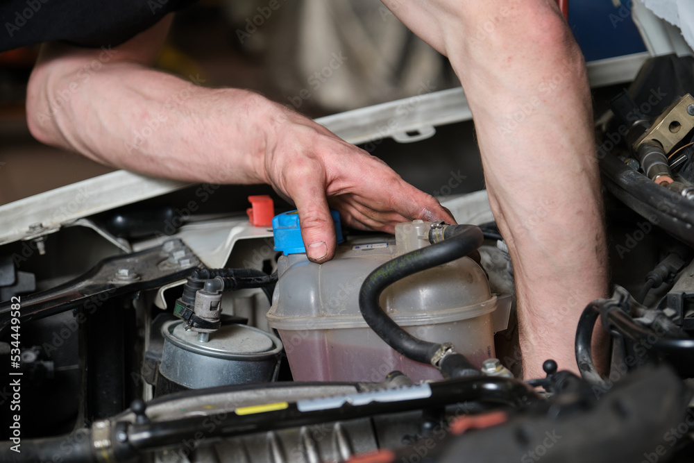 Car mechanic checking pulley on a car engine. Mechanics workshop. Car mechanic checking pulley on a car engine. Mechanics workshop.