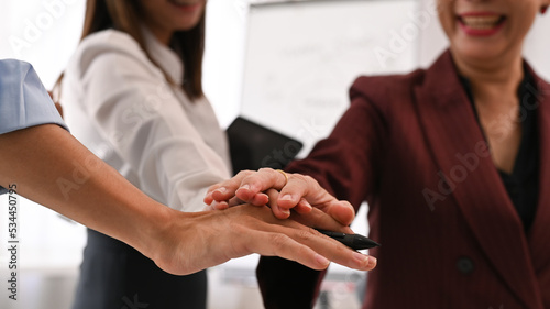 Close up image of successful businesspeople stacking hands together. Teamwork  collaboration and unity concept