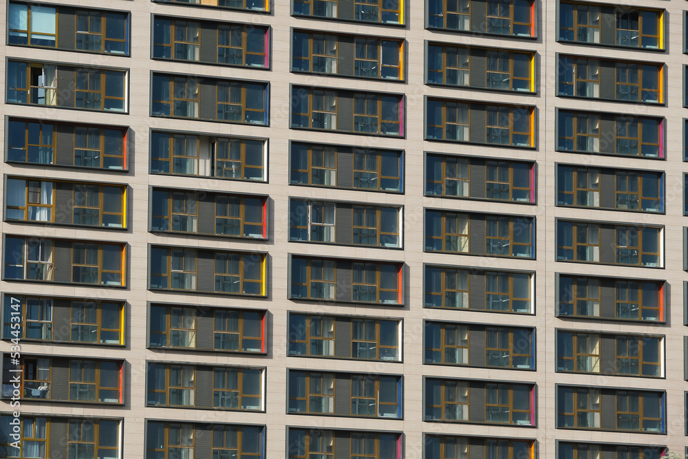 Apartment building facade with many windows as background