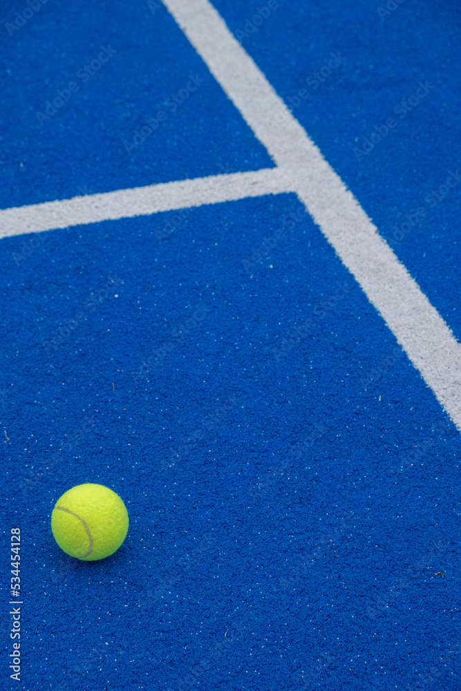 a ball on a blue paddle tennis court, racket sports
