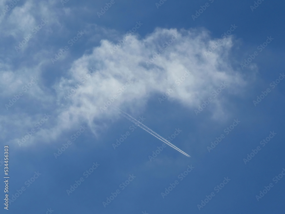 Contrail of smoke from jet engine of the airplane over the blue sky from the cloud Contrail of smoke from jet engine of the airplane over the blue sky from the cloud