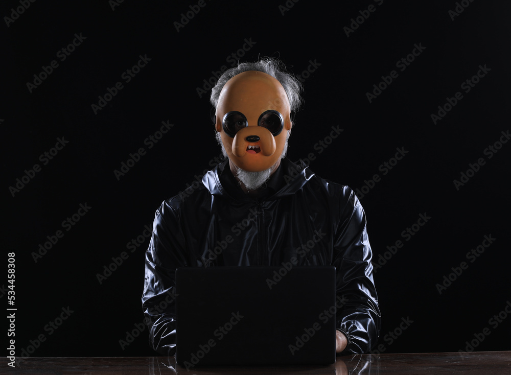 masked hacker with laptop at night masked hacker with laptop at night