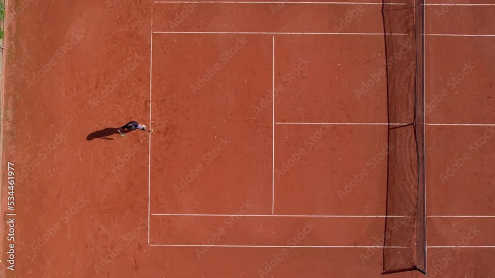 Aerial view of a tennis player serving a tennis ball during a competition tournament match, slow motion Aerial view of a tennis player serving a tennis ball during a competition tournament match, slow motion