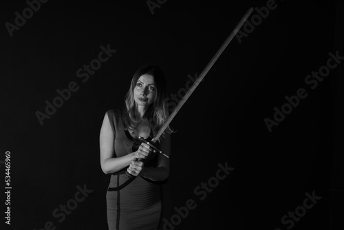 Low key portrait of a woman with vintage sword