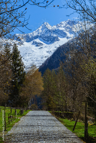 the mountains of val masino and val di mello with fresh snow, during a sunny day, near the town of San Martino, Italy - April 2022.