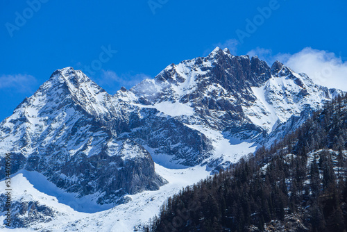 the mountains of val masino and val di mello with fresh snow, during a sunny day, near the town of San Martino, Italy - April 2022. © Roberto