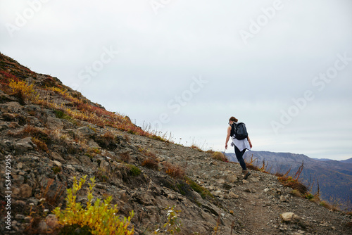 a woman hiking and trekking in the mountains in alaska for a day hike