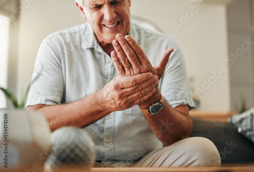 Senior man, hands and wrist joint pain in living room home from carpal tunnel, osteoporosis and arthritis. Elderly, sick and stress male, orthopedic muscle injury and fibromyalgia health risk problem photo