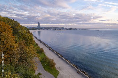 Sunrise over the Gulf of Gdansk on the boulevard in Gdynia. A view of the modern marina and the Sea Tower skyscraper.  © blesz