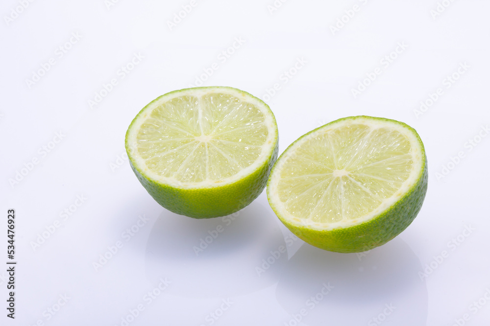 Green limes cut in half isolated on a white background.