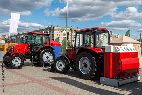 Two red wheeled tractors at an agricultural fair