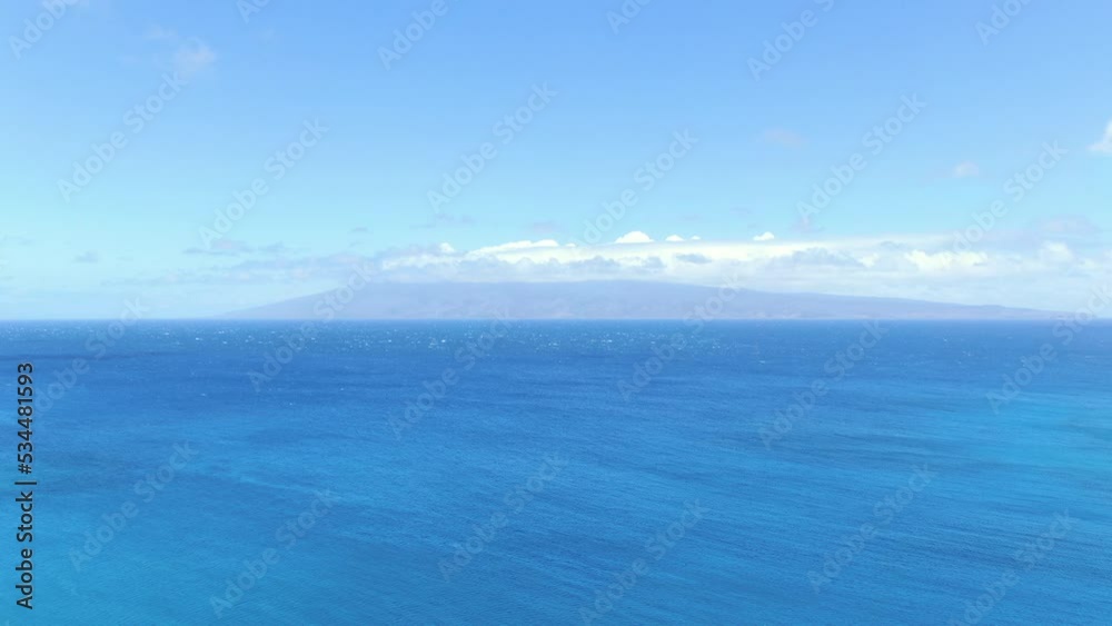 Aerial: Hawaii's deep blue ocean horizon looking out toward Moloka'i shrouded in vog. Aerial: Hawaii's deep blue ocean horizon looking out toward Moloka'i shrouded in vog.