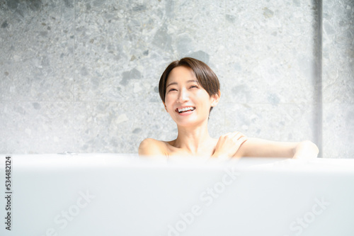 お風呂の湯舟でくつろぐ女性 photo