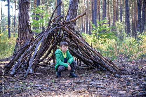 In the spring or autumn in the pine forest the boy plays he buil
