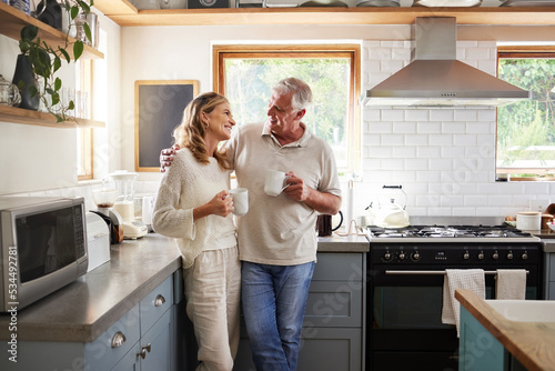 Senior, couple and drinking coffee with a love, marriage and happiness morning mindset at home. Happy smile and hug of a elderly woman and man with tea in a house kitchen together with quality time photo