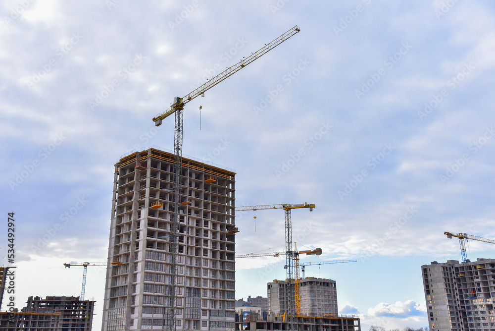 Сonstruction site with tower cranes on building construction. Builder on formworks. Cranes on pouring concrete in formwork. Tower cranes on construction. Built environment. Buildings renovation..