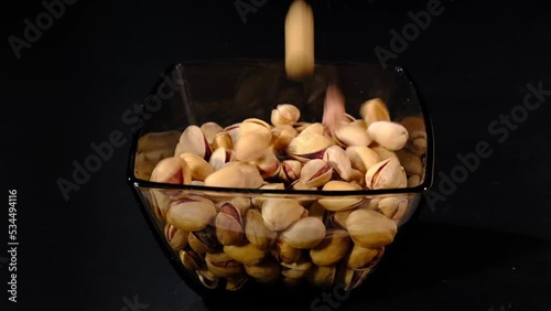 Salted pistachios in glass bowl photo