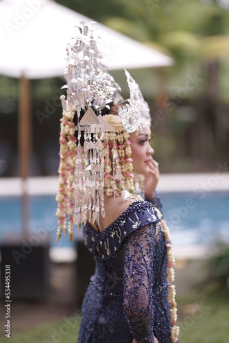 The model who is wearing suntiang traditional clothes from the city of padang, indonesia, looks very elegant and beautiful photo