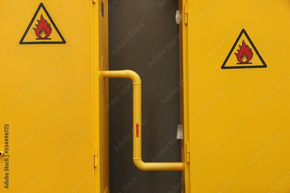 Yellow gas distribution cabinet near brown wall